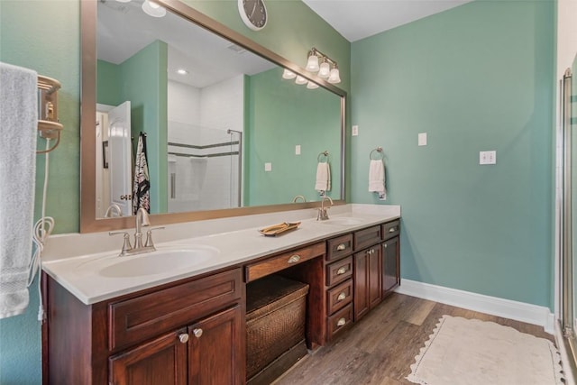 bathroom with a sink, a shower with door, and wood finished floors