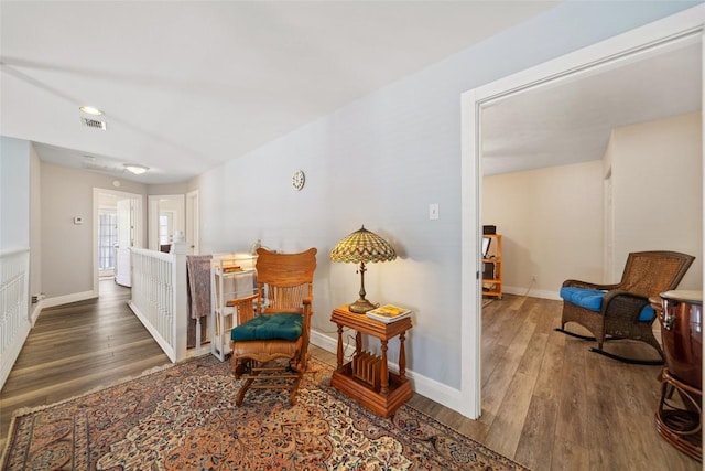 sitting room with baseboards and wood finished floors