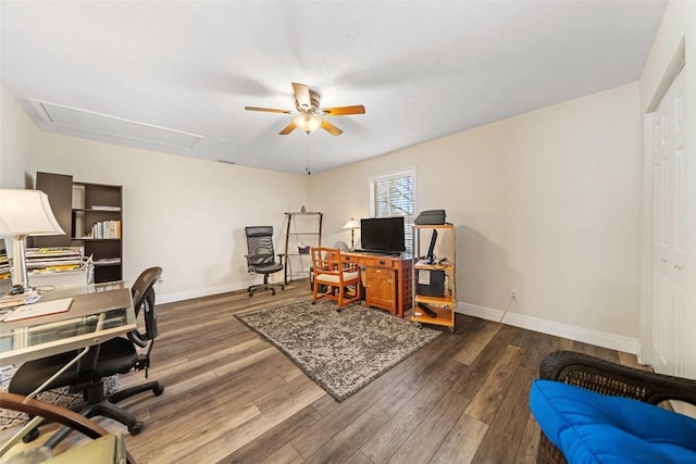 home office featuring baseboards, attic access, dark wood-type flooring, and ceiling fan