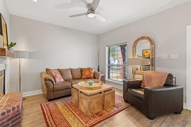 living room featuring ceiling fan, baseboards, and light wood-style floors