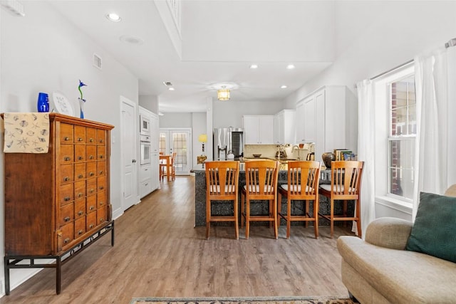 dining room with recessed lighting, light wood-type flooring, and visible vents