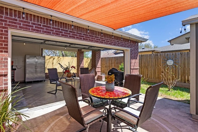 view of patio with outdoor dining space and fence