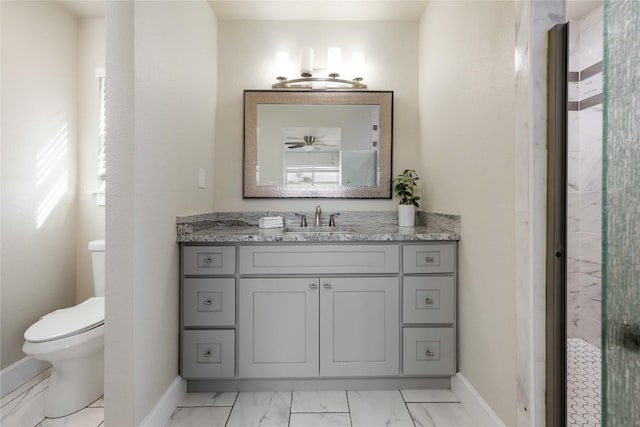 917 County Road 664, Devine, TX 78016 - bathroom featuring vanity, toilet, baseboards, and marble look tiles
