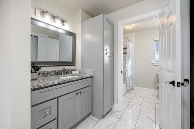917 County Road 664, Devine, TX 78016 - bathroom with marble look tiles, vanity, toilet, baseboards, and shower / bathtub combination with curtain