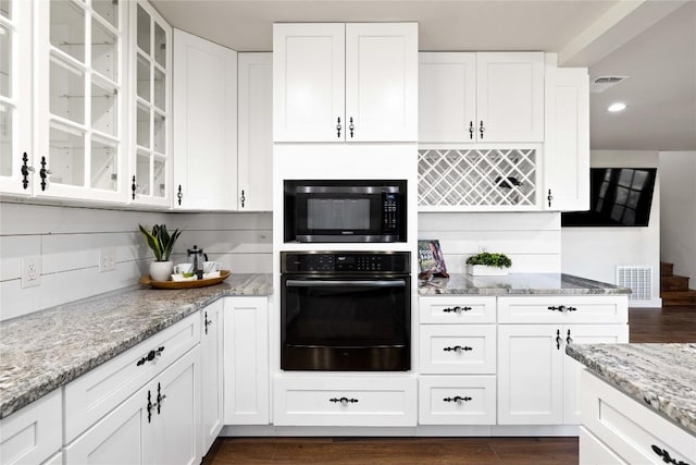 917 County Road 664, Devine, TX 78016 - kitchen with black appliances, white cabinetry, glass insert cabinets, and recessed lighting