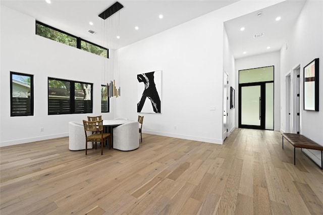 interior space with recessed lighting, a high ceiling, and light wood-style flooring