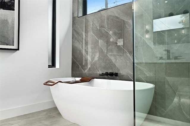 bathroom with a soaking tub and tile walls