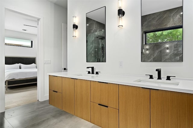 ensuite bathroom with double vanity, ensuite bathroom, a shower with door, and a sink