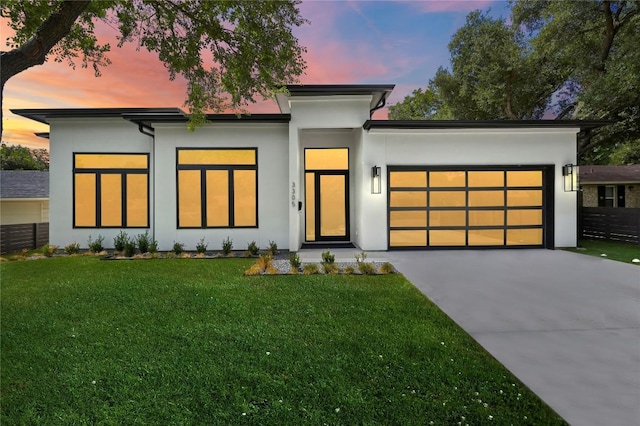 view of front of house featuring stucco siding, a front lawn, concrete driveway, and a garage