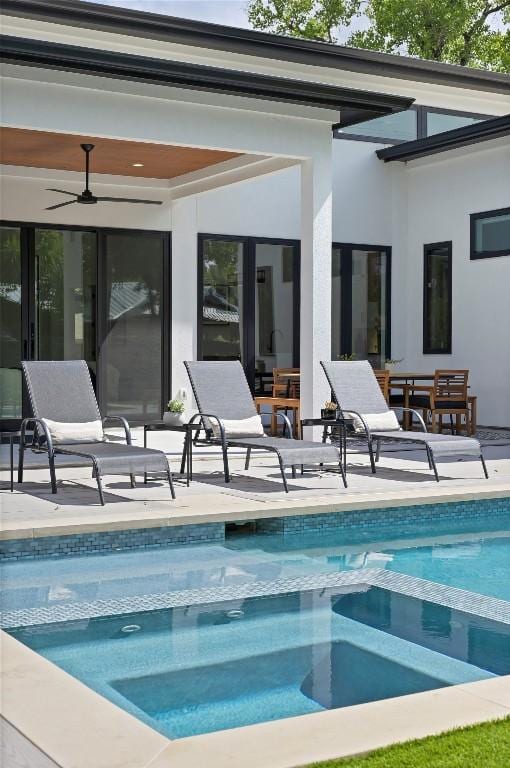 rear view of property featuring a pool with connected hot tub, ceiling fan, and a patio area