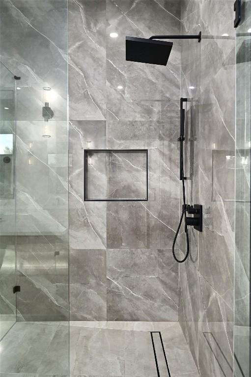 bathroom featuring a marble finish shower