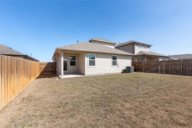 rear view of house featuring a patio, cooling unit, a fenced backyard, and a yard