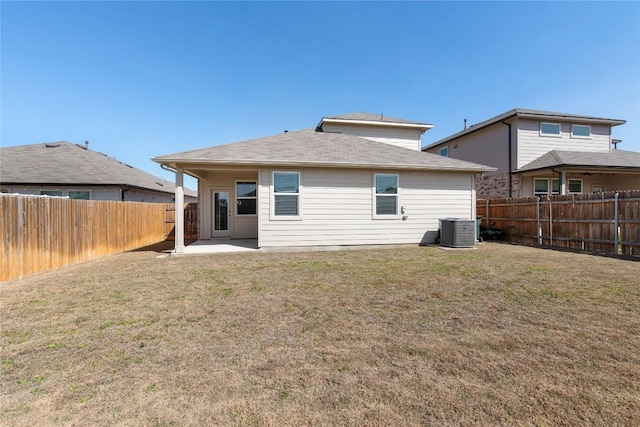 rear view of property featuring a yard, a patio, central AC, and a fenced backyard