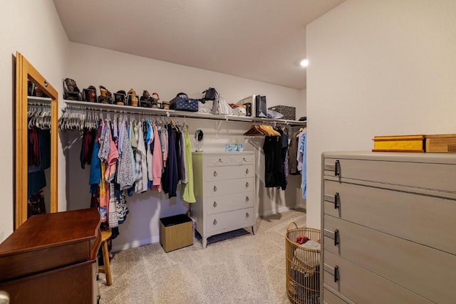 walk in closet featuring light colored carpet