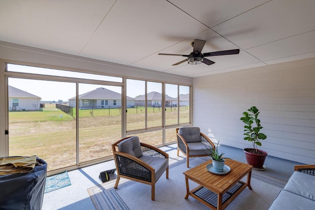 sunroom / solarium with a residential view, a healthy amount of sunlight, and ceiling fan