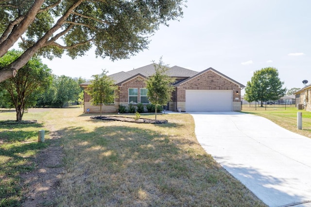 single story home with brick siding, an attached garage, driveway, and a front yard