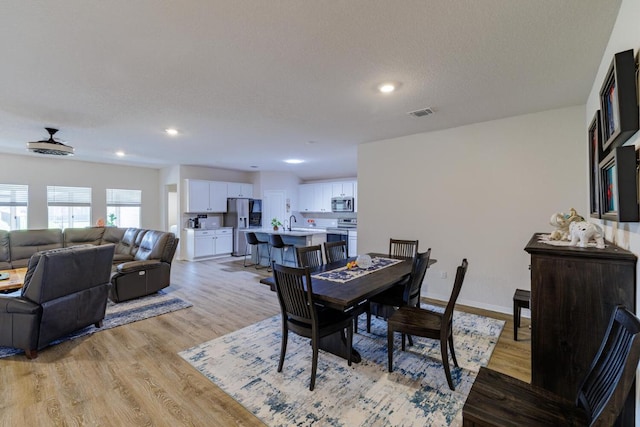 dining space featuring recessed lighting, baseboards, a textured ceiling, and light wood finished floors