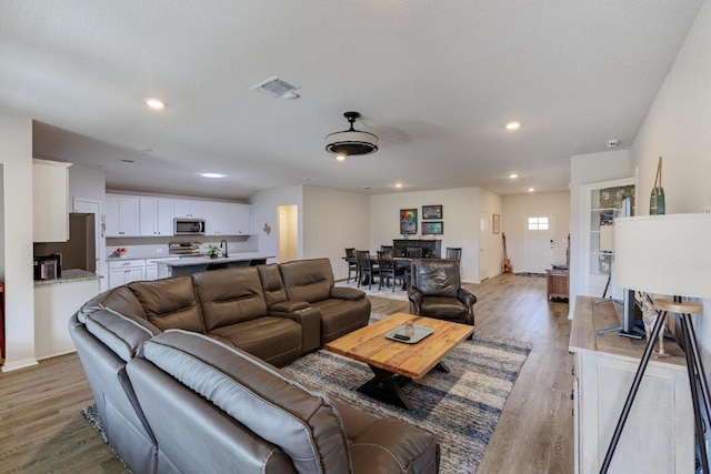 living area featuring recessed lighting, visible vents, and light wood-style flooring