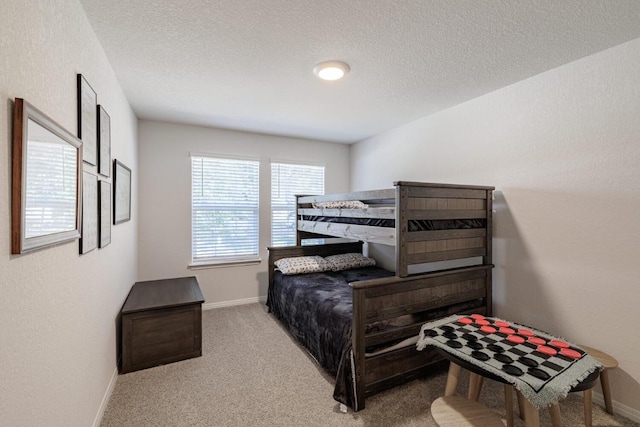 bedroom with carpet, baseboards, and a textured ceiling