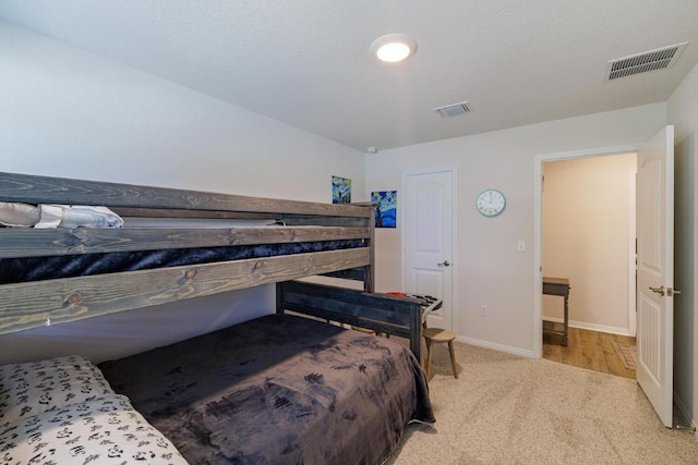 bedroom featuring light colored carpet, visible vents, and baseboards