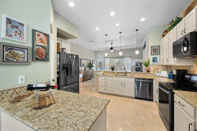 kitchen with black appliances, a peninsula, tasteful backsplash, and white cabinetry