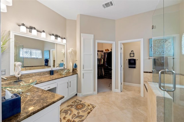 bathroom featuring a spacious closet, visible vents, tile patterned flooring, a stall shower, and vanity