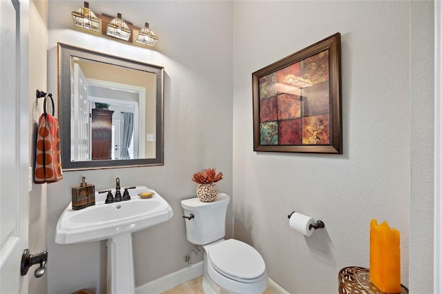 bathroom with toilet and baseboards