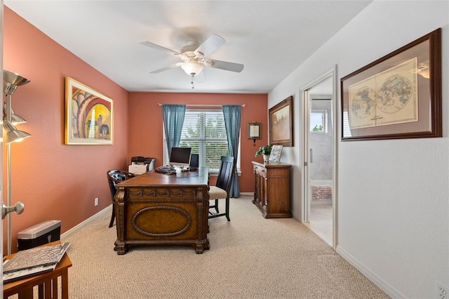 carpeted home office with baseboards and ceiling fan