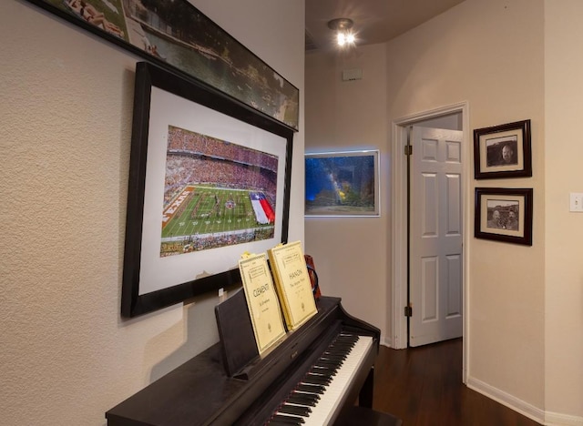 hallway featuring wood finished floors and baseboards