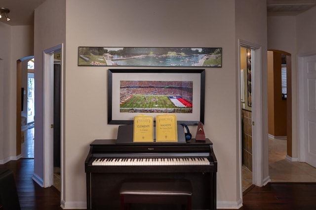 room details featuring baseboards, arched walkways, and wood finished floors