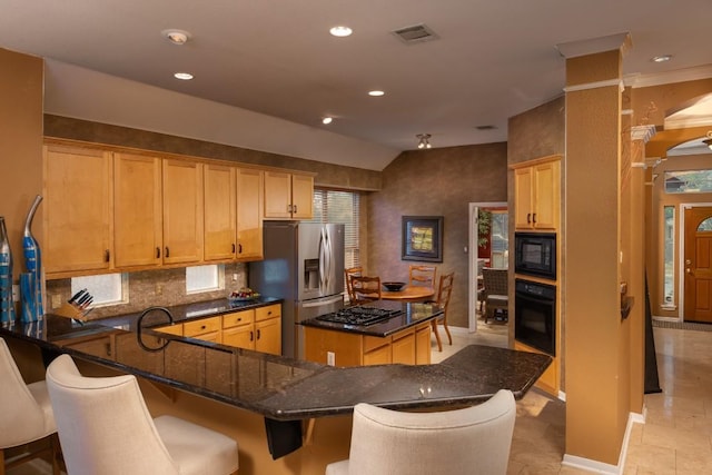 kitchen with visible vents, a center island, decorative backsplash, dark stone countertops, and black appliances