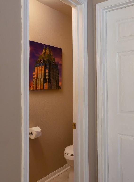 bathroom with tile patterned floors, toilet, and baseboards