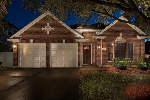 view of front facade with brick siding, an attached garage, and driveway