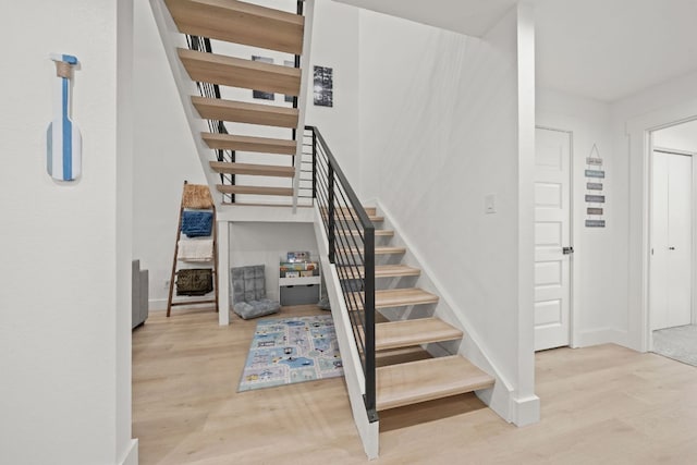 staircase with wood finished floors and baseboards