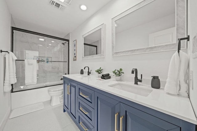 full bathroom with tile patterned flooring, double vanity, bath / shower combo with glass door, and a sink