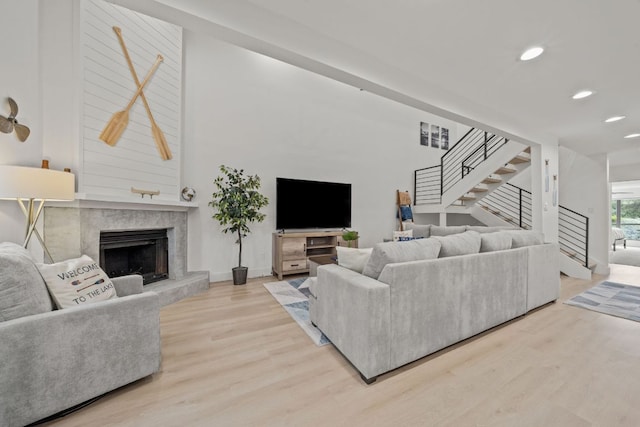 living room with recessed lighting, stairway, wood finished floors, and a fireplace