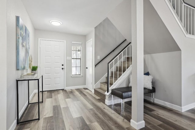 foyer featuring stairway, baseboards, and wood finished floors