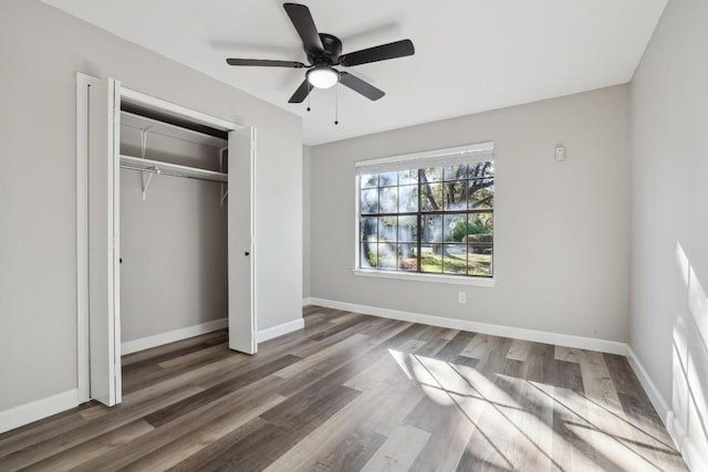 unfurnished bedroom featuring wood finished floors, baseboards, a closet, and ceiling fan