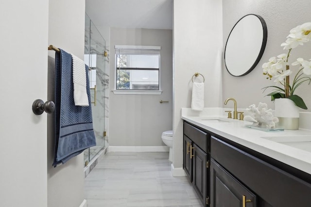 full bath with a stall shower, toilet, baseboards, and a sink