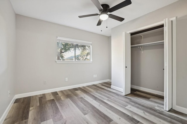 unfurnished bedroom with ceiling fan, a closet, baseboards, and wood finished floors