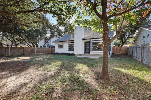 back of house featuring a yard, a fenced backyard, a chimney, and a shingled roof