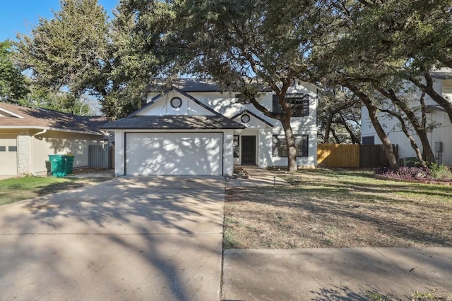 traditional home with a garage, concrete driveway, and fence