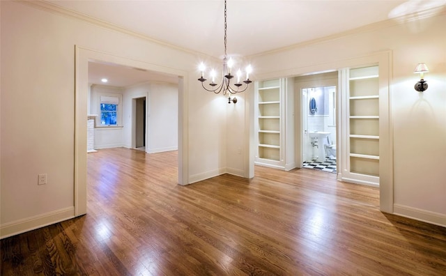 unfurnished dining area featuring baseboards, a notable chandelier, and wood finished floors