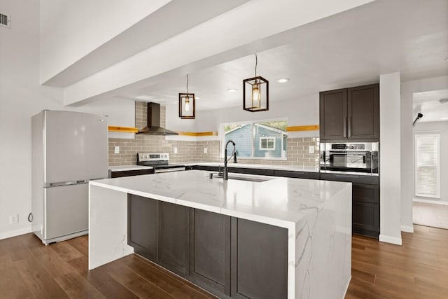 kitchen with a sink, dark wood-type flooring, wall chimney exhaust hood, and stainless steel appliances