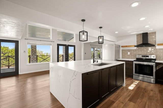 kitchen featuring a sink, decorative backsplash, stainless steel appliances, wall chimney exhaust hood, and open shelves