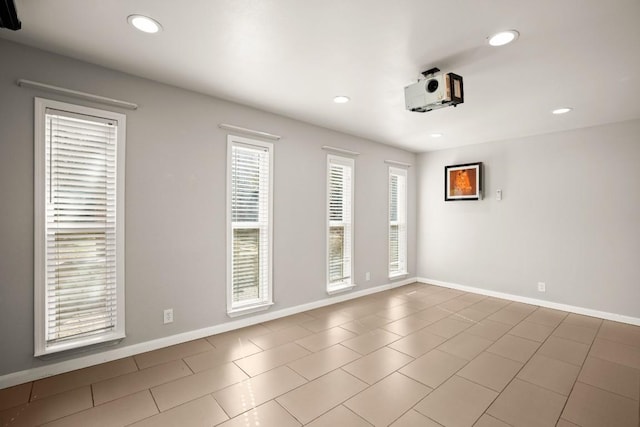 unfurnished room featuring recessed lighting and baseboards