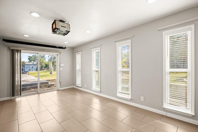 empty room with light tile patterned flooring, recessed lighting, and baseboards