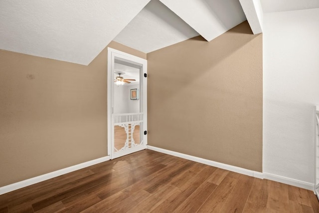 additional living space with ceiling fan, baseboards, lofted ceiling, and wood finished floors