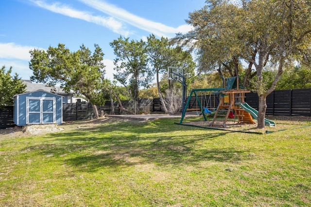 view of yard featuring a fenced backyard, an outdoor structure, a shed, and a playground
