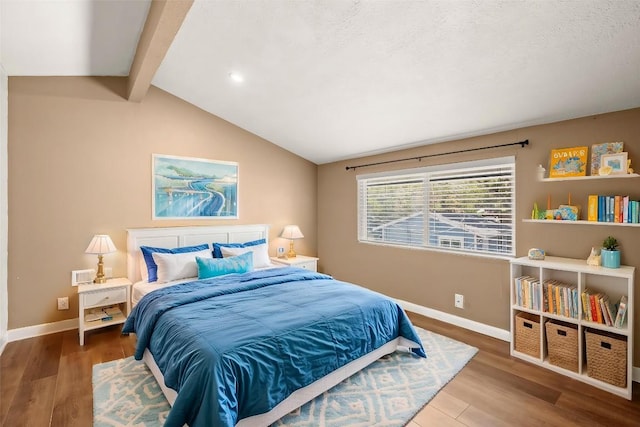 bedroom featuring lofted ceiling with beams, wood finished floors, baseboards, and recessed lighting